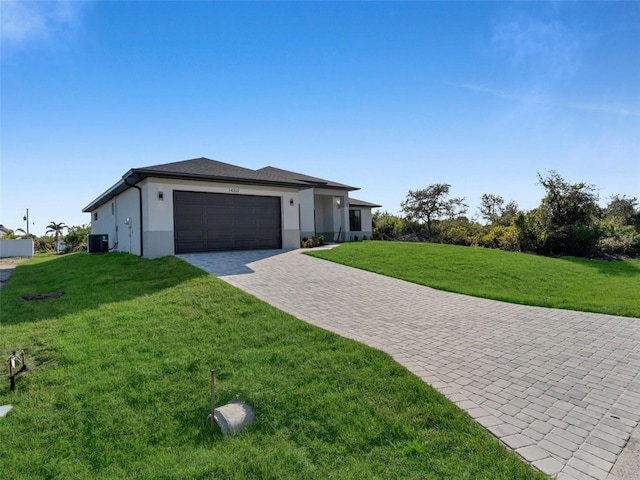 view of front of property with an attached garage, cooling unit, decorative driveway, a front lawn, and stucco siding