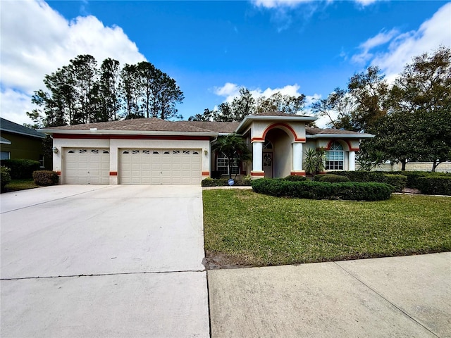 view of front of home with driveway, stucco siding, an attached garage, and a front yard