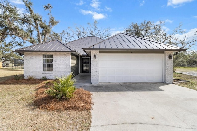 view of front of property with a standing seam roof, brick siding, driveway, and metal roof