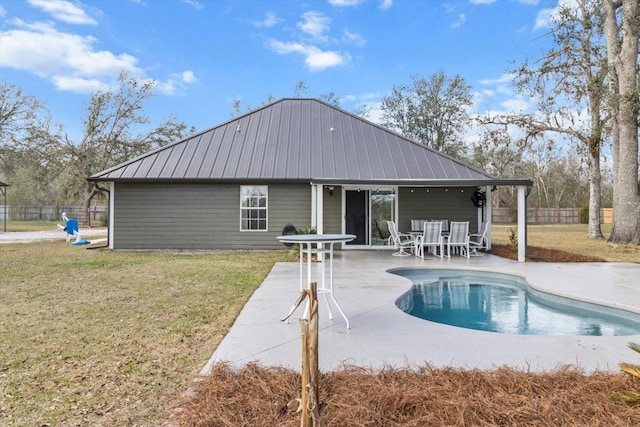 rear view of property with a yard, fence, a fenced in pool, and a patio