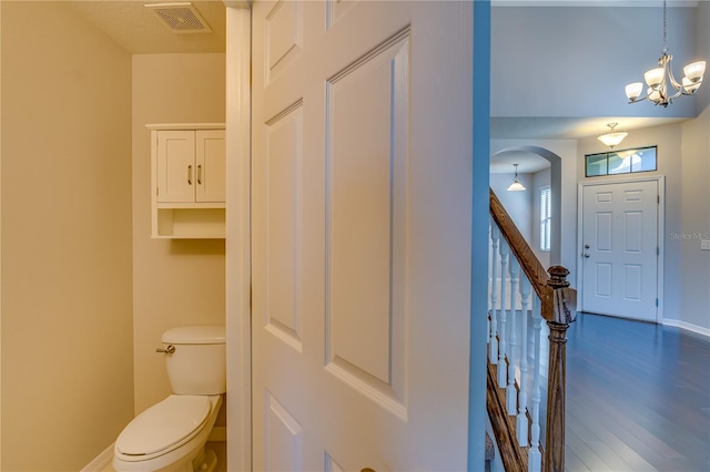 bathroom featuring visible vents, toilet, wood finished floors, a chandelier, and baseboards