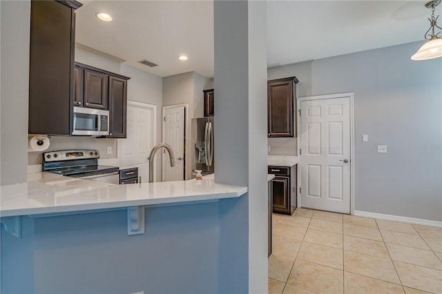 kitchen featuring dark brown cabinetry, visible vents, stainless steel appliances, and light tile patterned flooring