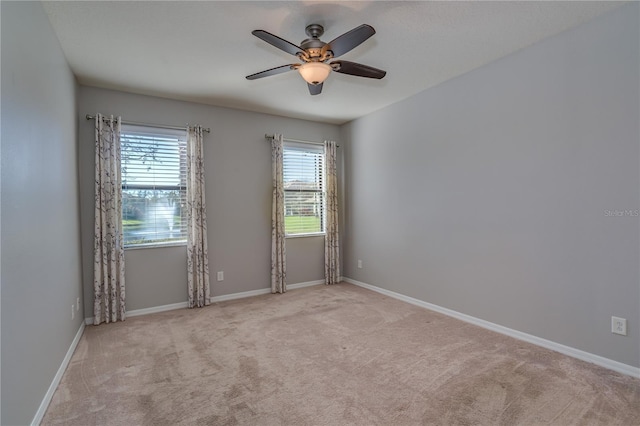 empty room featuring carpet floors, baseboards, and a ceiling fan