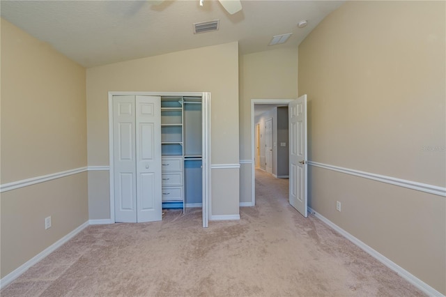 unfurnished bedroom featuring carpet, visible vents, vaulted ceiling, and a closet