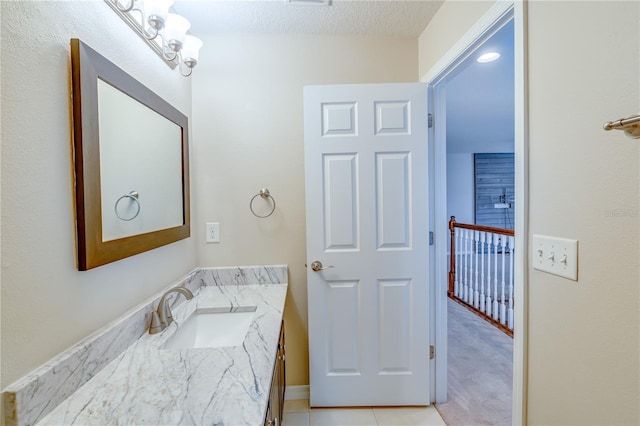 bathroom featuring a textured ceiling, tile patterned flooring, and vanity