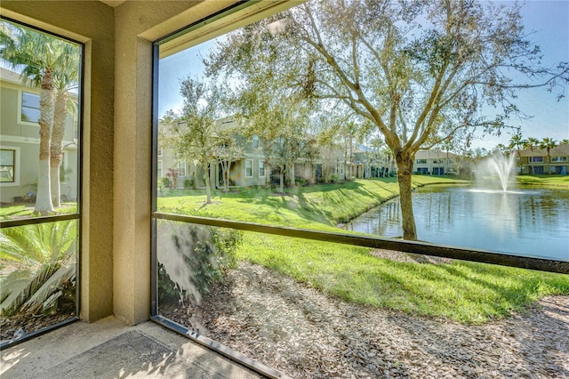 unfurnished sunroom with a water view and a residential view