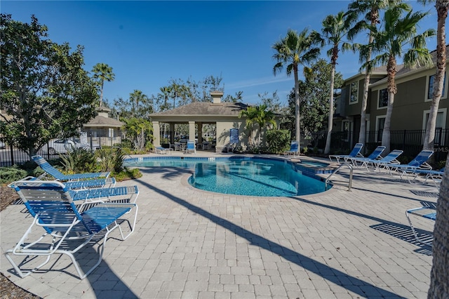 view of pool featuring a patio, a gazebo, fence, and a pool with connected hot tub