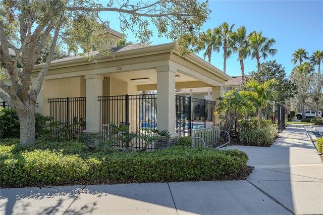 view of front of home featuring fence, an outdoor pool, and stucco siding