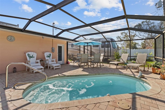 view of swimming pool with glass enclosure, fence, a fenced in pool, and a patio