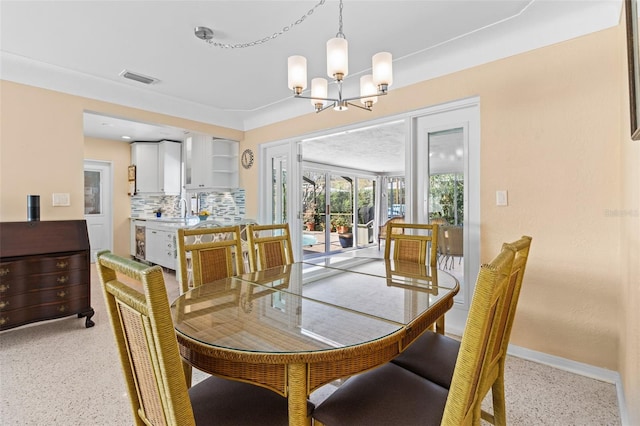 dining space featuring baseboards, visible vents, light speckled floor, and a chandelier