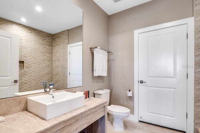 bathroom with toilet, visible vents, and vanity