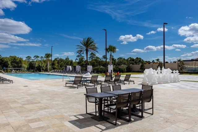 community pool with a patio area and fence