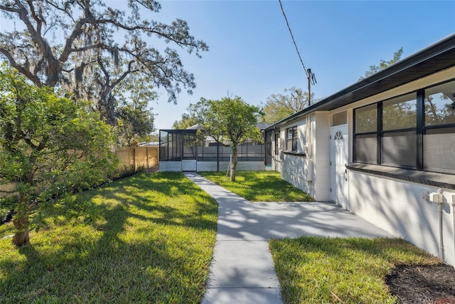 view of yard with a sunroom and fence