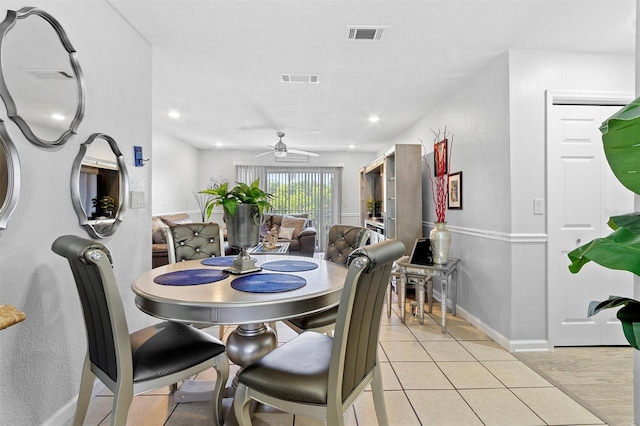 dining room with a ceiling fan, visible vents, baseboards, and light tile patterned floors