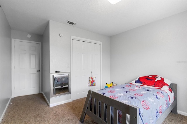 carpeted bedroom featuring a closet, visible vents, and baseboards