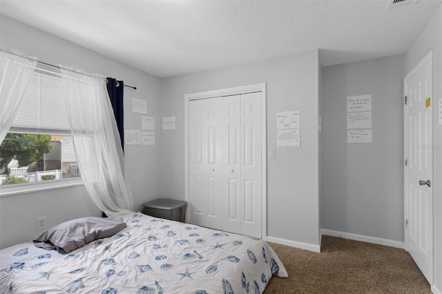 carpeted bedroom with baseboards and a closet