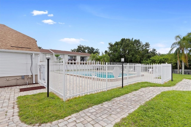 view of swimming pool with a patio, a lawn, fence, and a fenced in pool