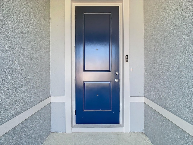 view of exterior entry featuring stucco siding