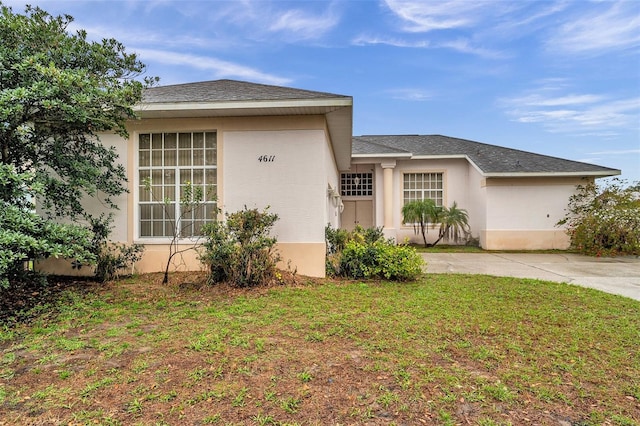 view of front of house with a front lawn and stucco siding