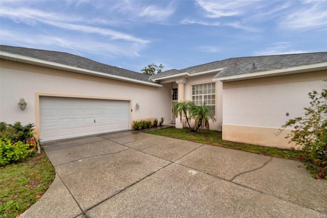 view of front of home featuring concrete driveway, an attached garage, and stucco siding