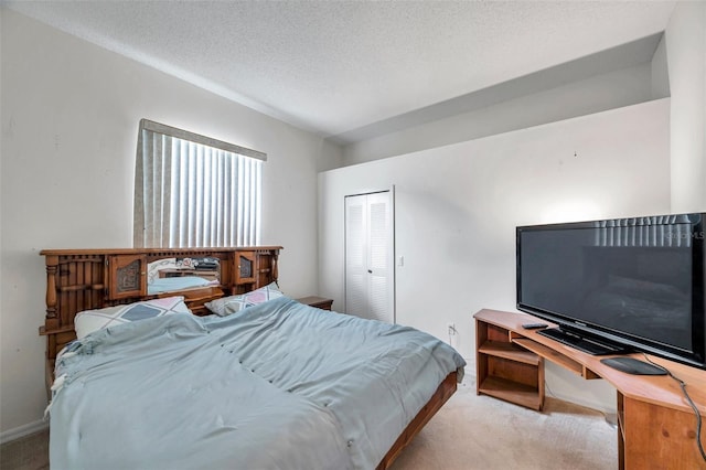 bedroom with light carpet, a textured ceiling, and a closet