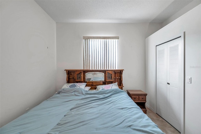 bedroom featuring a closet, light colored carpet, and a textured ceiling