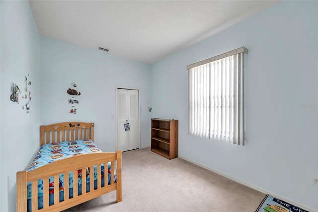 bedroom with light carpet, a closet, and visible vents