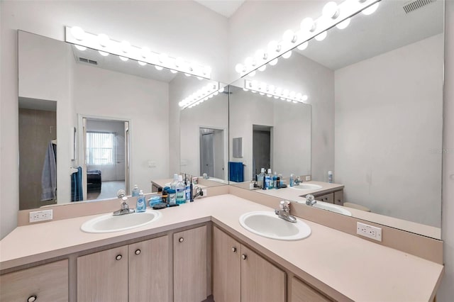 ensuite bathroom with double vanity, visible vents, a sink, and ensuite bathroom