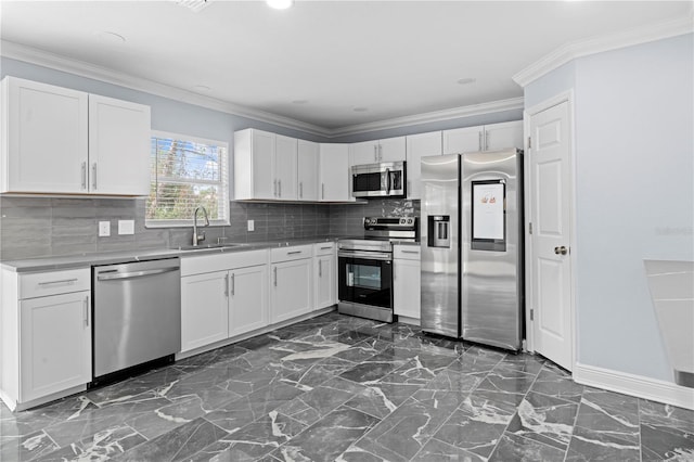 kitchen featuring marble finish floor, stainless steel appliances, crown molding, and a sink