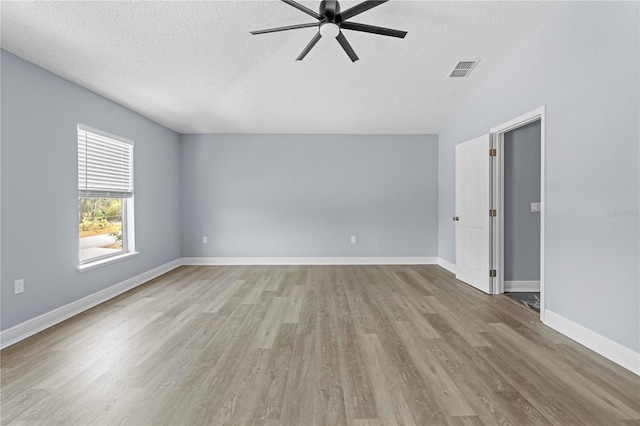 empty room featuring visible vents, baseboards, wood finished floors, a textured ceiling, and a ceiling fan