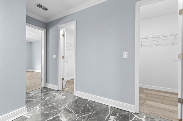 spare room with visible vents, baseboards, marble finish floor, and crown molding