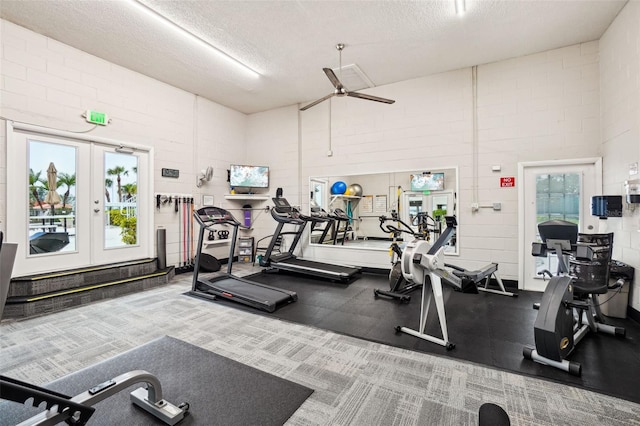 workout area with french doors, ceiling fan, and a textured ceiling