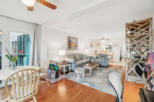 living area with a ceiling fan and wood finished floors