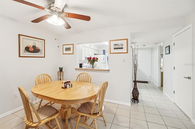 dining area featuring ceiling fan, baseboards, and light tile patterned flooring