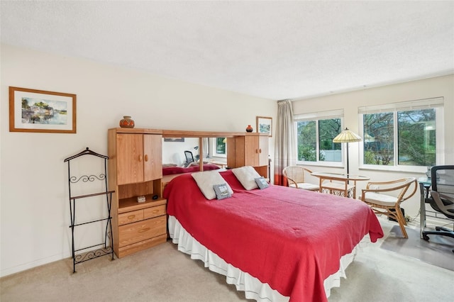 bedroom with light carpet, baseboards, and a textured ceiling