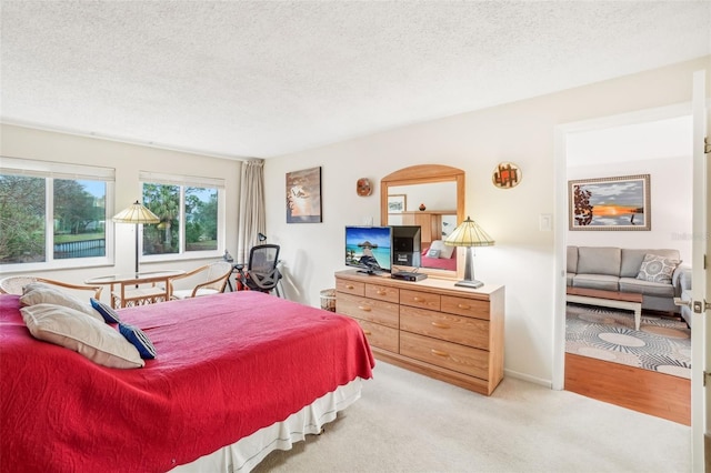 bedroom with light carpet and a textured ceiling