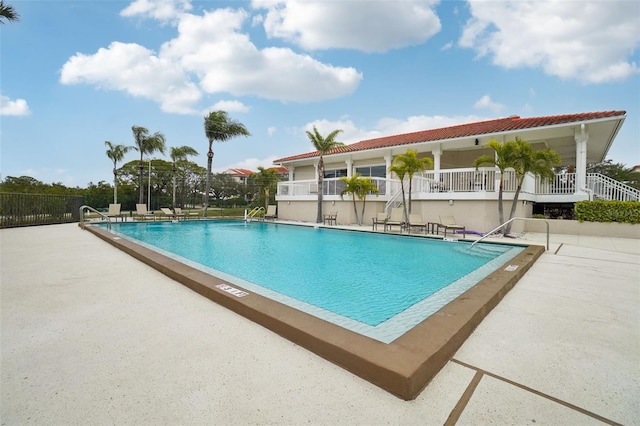 community pool featuring fence and a patio