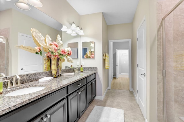 bathroom with tile patterned floors, a sink, a shower stall, and double vanity