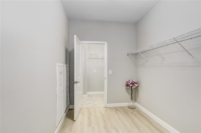 interior space featuring baseboards and light wood finished floors