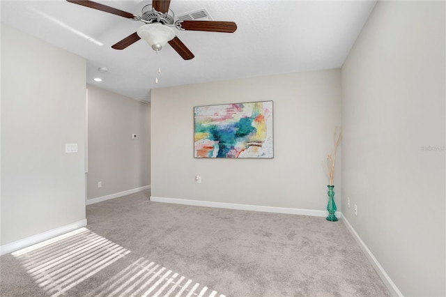 empty room with a ceiling fan, light carpet, and baseboards