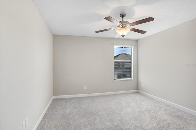 empty room featuring light carpet, ceiling fan, and baseboards