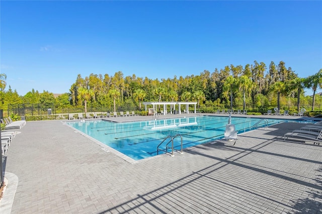 community pool with a patio area and fence