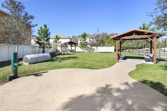 view of property's community with a gazebo, a lawn, and fence