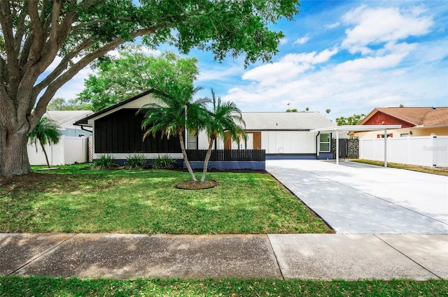 view of front of house with fence, concrete driveway, and a front yard