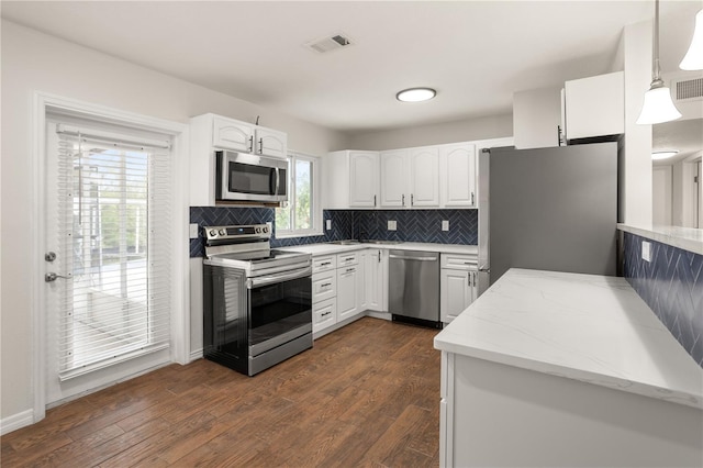 kitchen featuring visible vents, white cabinets, appliances with stainless steel finishes, dark wood-style floors, and pendant lighting