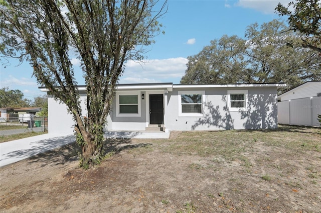 ranch-style home featuring entry steps, fence, and stucco siding