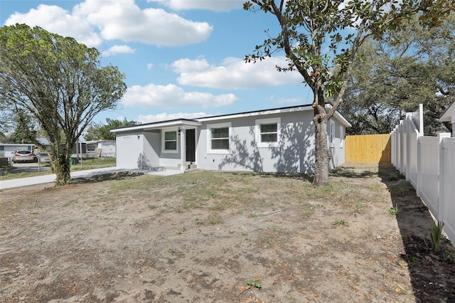 manufactured / mobile home with fence and stucco siding