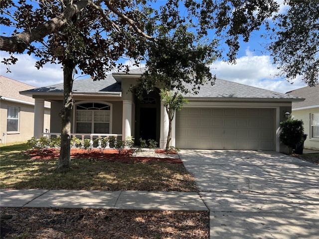 ranch-style house featuring concrete driveway, roof with shingles, an attached garage, and stucco siding