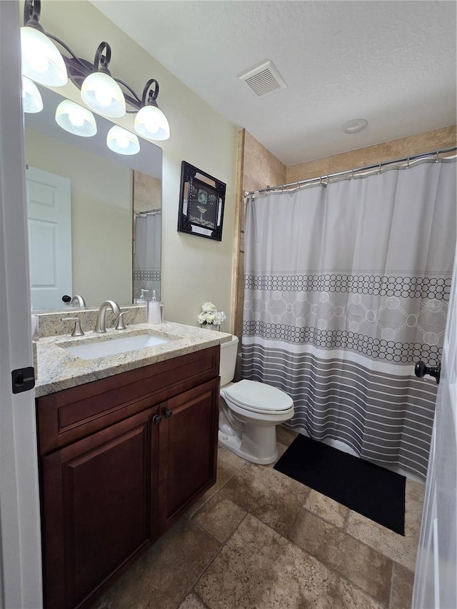 full bath with stone finish floor, visible vents, vanity, and toilet