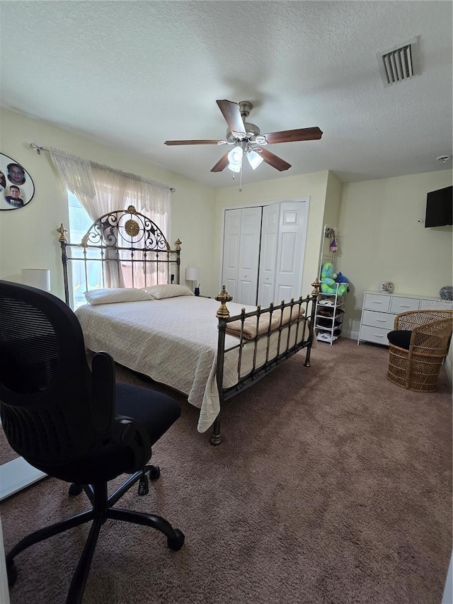 bedroom with carpet floors, a closet, visible vents, a ceiling fan, and a textured ceiling